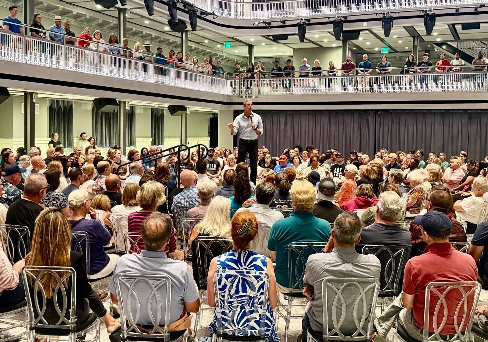 Beto standing at the center of a crowd of supporters in Baltimore.