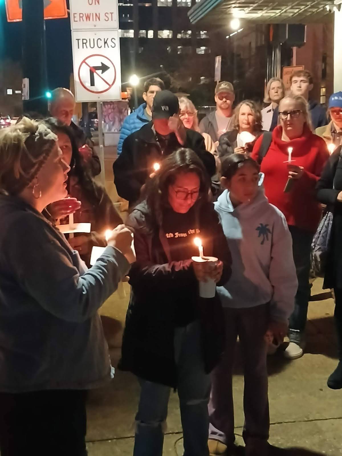 People holding candles at a vigil.