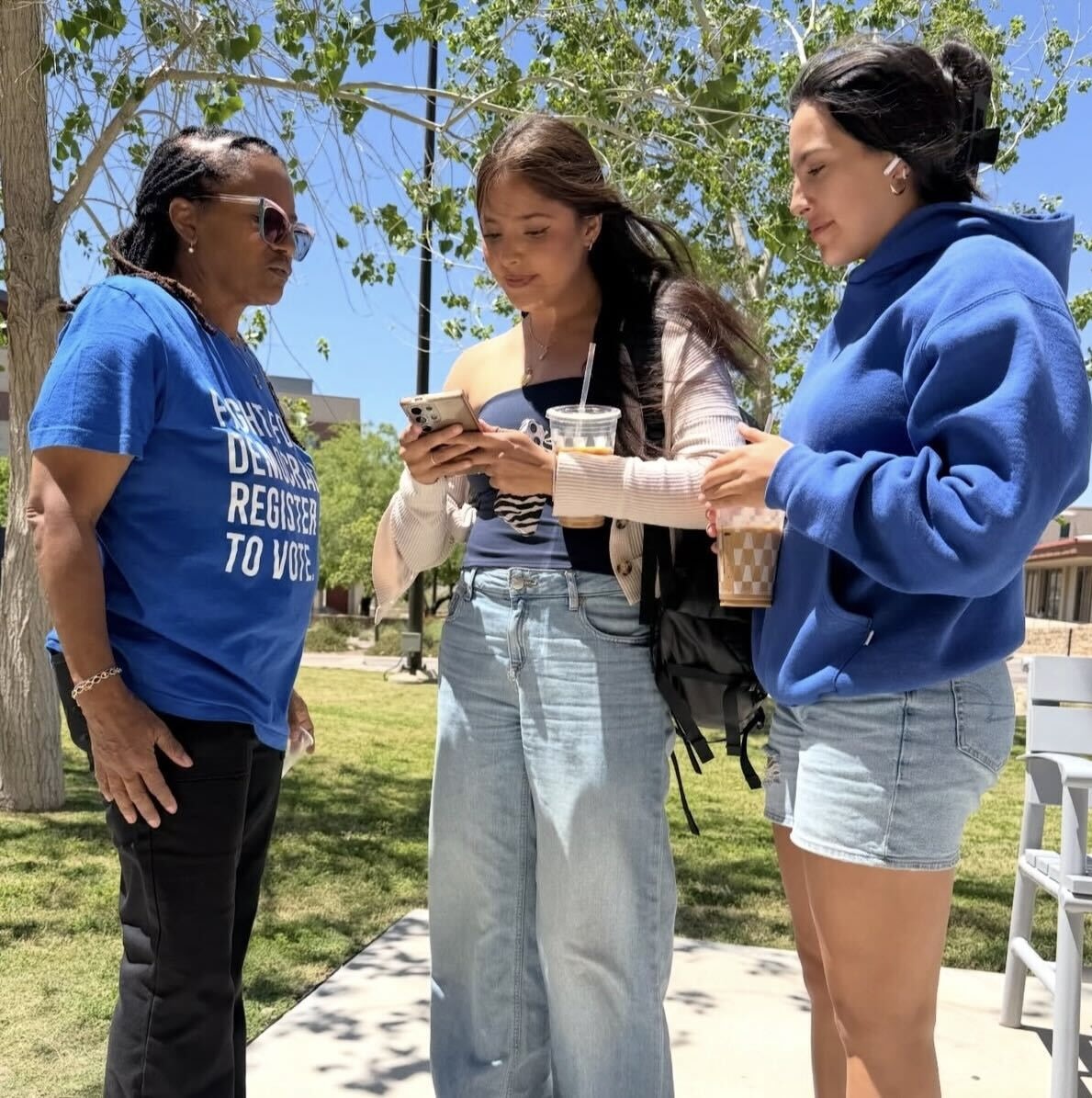 A Powered by People volunteer talking to two voters.